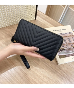 Close-up of black V-quilted long wallet featuring gold zipper and a leather wristlet strap