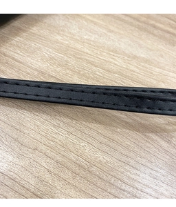 Macro view of black leather strap showing precise double-line stitching and fine texture