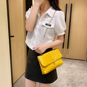 Sac bandoulière en cuir jaune avec surpiqûres en V, chaîne dorée et fermoir métallique