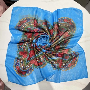 Detail of sky blue floral square scarf with golden metallic stripes and retro pattern
