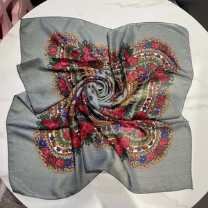 Detail of rose floral scarf with gold metallic thread and hemmed edges on marble