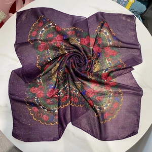 Macro detail of dark purple floral scarf with gold metallic stripes and red roses pattern