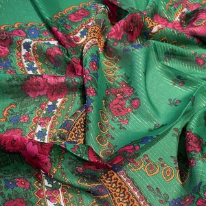 Close-up of ethnic floral green scarf with gold threads and detailed rose patterns