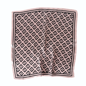 Pink satin square scarf with black geometric patterns shown in a flat lay view