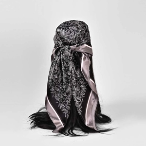 Detailed close-up of a vintage paisley silk scarf tied on hair showing print texture