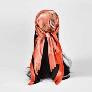 Vintage silk scarf with orange and black floral patterns styled as a French headwrap