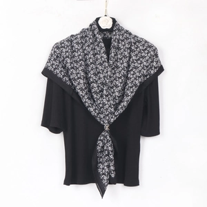 Floral print scarf paired with a black ribbed top featuring an elegant golden ring buckle