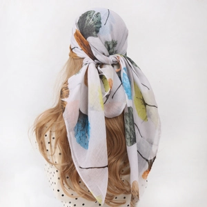 White cotton linen scarf with colorful ginkgo leaf print shown on a model head