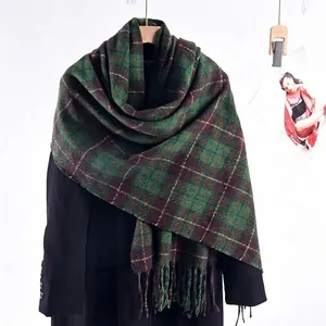 Green and brown plaid oversized scarf with tassels over a black blazer for winter style