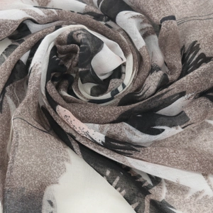 Detailed texture of lightweight voile scarf featuring ethnic floral print in warm tones