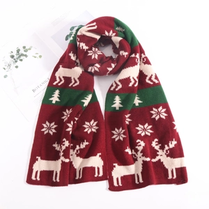 Detail of Christmas knitted scarf with reindeer, snowflake, and tree patterns in red and green