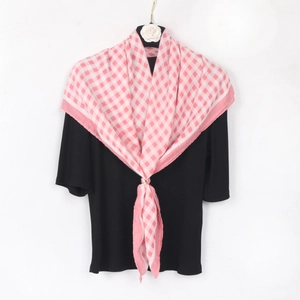 Pink and white checkered cotton linen headscarf displayed on a black top with camellia