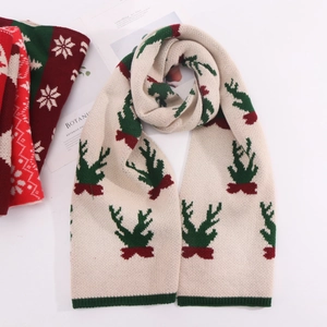 Close-up of knit Christmas scarf featuring reindeer patterns and green ribbed edges