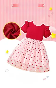 Detail von rotem Strickoberteil mit Flügelärmeln und rosa Tüllrock mit Herzen