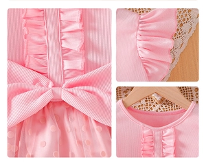 Detalle de vestido rosa de algodón con volantes, lazo grande y falda de malla de lunares