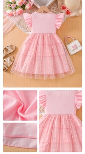 Detalle de un vestido rosa para niña con capas de tul de lunares y mangas con volantes