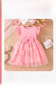 Detail of pink girls' dress featuring a large waist bow and 3D floral mesh skirt