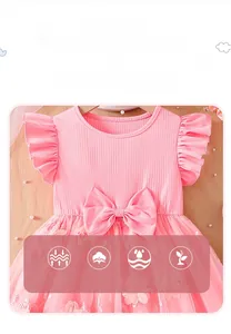 Detail of pink girls dress showing cotton bodice, large waist bow and 3D floral embroidery