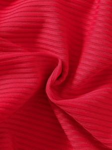 Detailed close-up of girls' red ribbed knit dress with soft vertical stripe texture