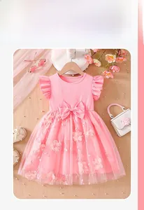 Detail of pink girls' dress with floral embroidery, mesh tutu skirt and large bow accent