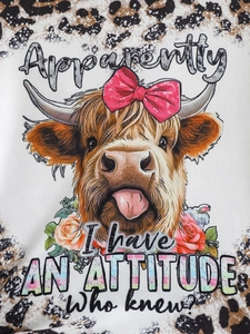 Close-up of baby girl outfit fabric featuring Highland cow print and leopard patterns