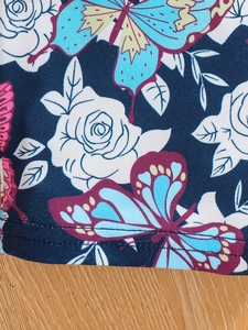 Close-up of floral and butterfly print fabric with durable double-needle stitching detail