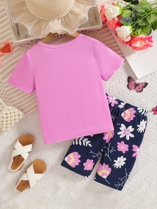 Ensemble d'été fille avec t-shirt rose, short à fleurs et sandales blanches sur fond texturé