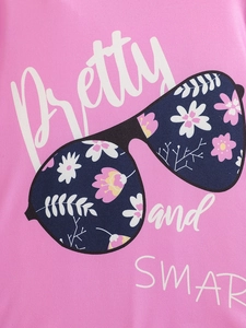 Gros plan d'un T-shirt rose avec motif de lunettes à fleurs et texte Pretty and SMART