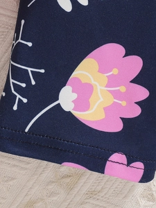 Détail macro du tissu floral bleu marine avec imprimé rose et coutures doubles précises