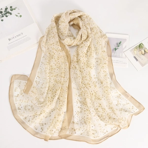 Detailed macro view of apricot floral chiffon scarf texture with elegant hemmed edges