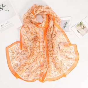 Detail of thin orange floral chiffon scarf showing lightweight translucent fabric texture