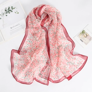 Detail of floral chiffon scarf with delicate pink patterns and clean red edge stitching