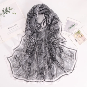 Detail of lightweight black and white paisley chiffon scarf with floral pattern border