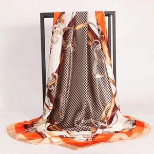 90cm silk square scarf with orange houndstooth and chain print on metal rack