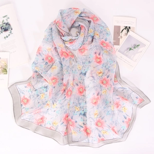 Close-up of floral georgette silk scarf with pink and yellow flowers on grey base