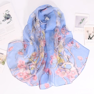 Detail of light blue georgette scarf with pink cherry blossom print on a white background