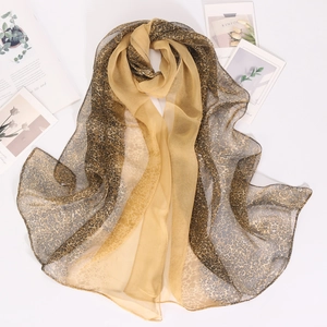 Detail eines dünnen Chiffon-Schals mit Leopardenmuster, goldener Satin-Patchwork-Textur