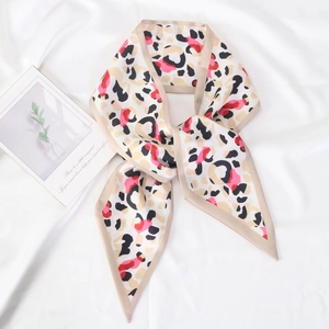 Pink and black leopard print satin skinny scarf displayed on white wrinkled fabric background
