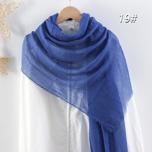 Détail de l'écharpe en coton et lin bleu roi avec texture froissée et bords à franges