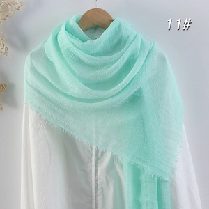 Écharpe en coton et lin vert menthe unie avec franges sur cintre en bois