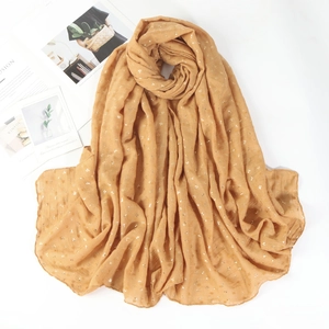 Detail of mustard yellow cotton linen scarf with elegant gold foil stamped leaf patterns