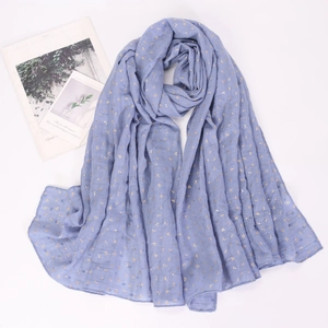 Detail of light blue cotton linen scarf with elegant gold foil leaf pattern texture