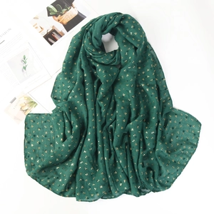 Detail of dark green lightweight cotton linen hijab scarf with golden leaf patterns