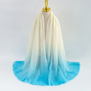 Detail of soft gradient scarf with fringe edges hanging on a display stand