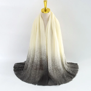 Detail of lightweight gradient shawl scarf with soft fringed edges and ombré transition