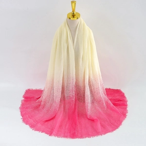 Detail of beige and bright pink gradient scarf with fine fringe trim and soft fabric