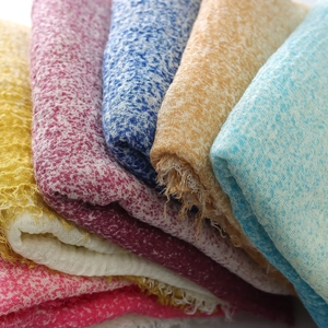Detailed macro view of vibrant gradient scarf fabric showing texture and frayed edges