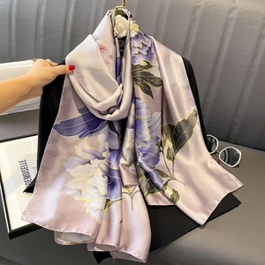 Elegant lilac floral satin scarf with large purple peonies displayed on a black blazer