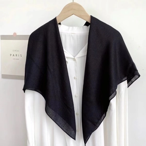 Minimalist black square scarf for women styled over a white shirt on a wooden hanger