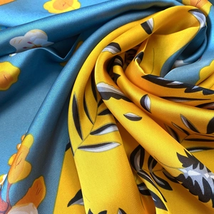 Vibrant floral silk scarf with yellow and blue contrast pattern in elegant satin texture